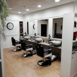 Interior de peluquería con mobiliario de color blanco