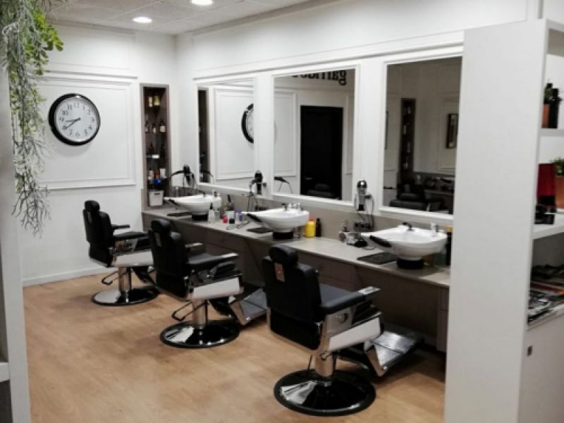 Interior de peluquería con mobiliario de color blanco