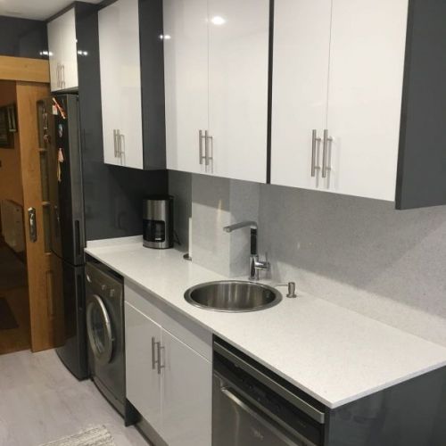 Muebles de cocina de madera de color gris y encimera en blanco