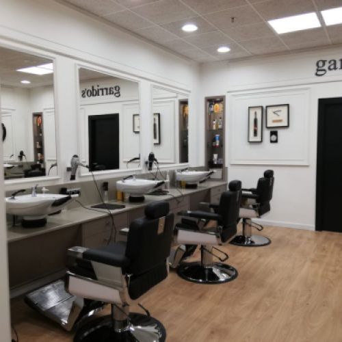 Interior de peluquería con paredes revestidas de madera de color blanco