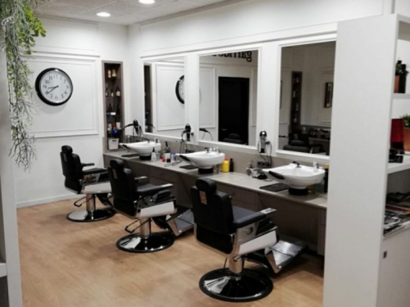 Interior de peluquería con mobiliario de color blanco