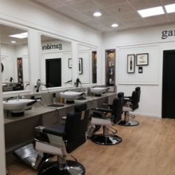 Interior de peluquería con paredes revestidas de madera de color blanco