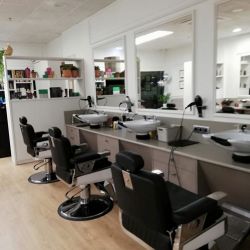 Peluquería con estanterías y paredes de madera de color blanco