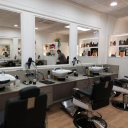 Interior de peluquería con paredes revestidas de madera blanca