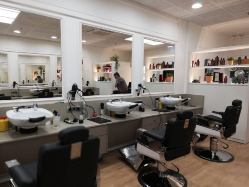 Interior de peluquería con paredes revestidas de madera blanca