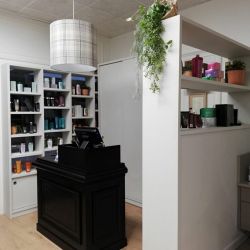 Peluquería con estanterías y expositores de madera de color blanco