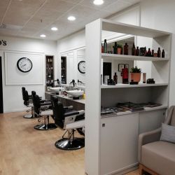 Interior de peluquería con paredes y estanterías de madera