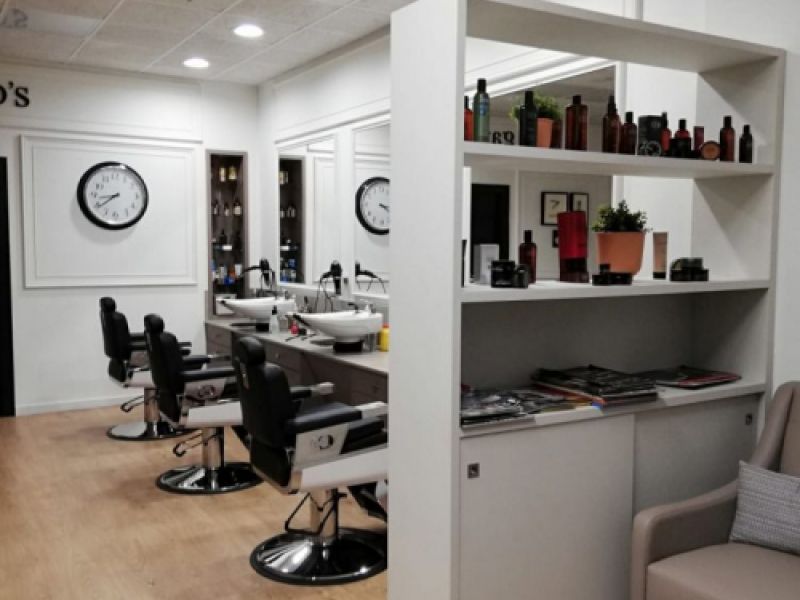 Interior de peluquería con paredes y estanterías de madera